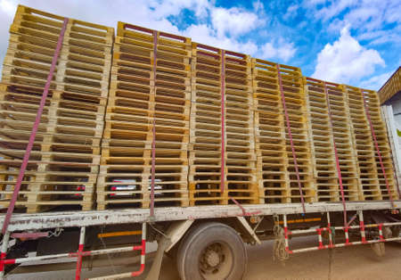 Worker driving forklift to loading and unloading wooden pallets from truck to warehouse cargo...