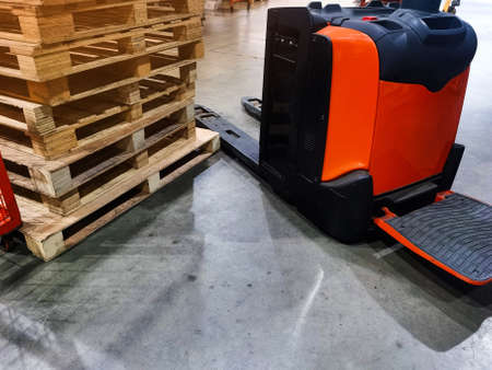 Worker driving forklift loading shipment carton boxes goods on wooden pallet at loading dock from...