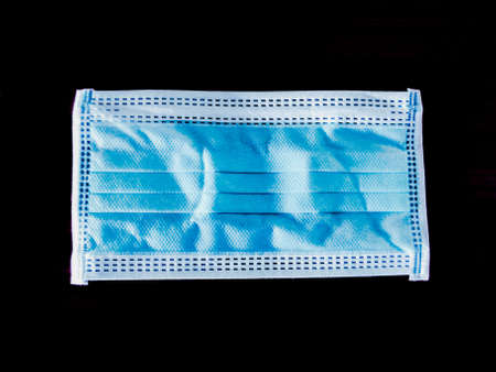Blue surgical face mask on black background,  Health care concept and can protect virus covid-19