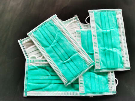 Green surgical face mask on black background,  Health care concept and can protect virus covid-19,...