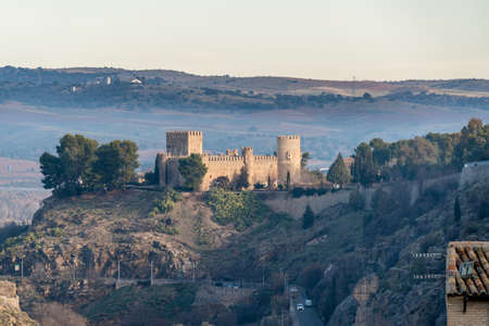 Morning mist at Castle of San Servando, medieval castle in Toledo, Spain, reflected on the Tagus River depicted in El Greco's painting View of Toledo. Occupied by Knights Templar, now a youth hostelのeditorial素材