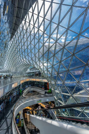 Frankfurt - July 26, 2016. People standing on the longest escalator in Germany, at futuristic architecture Myzeil shoping center building. Designed by Massimiliano Fuksas.のeditorial素材