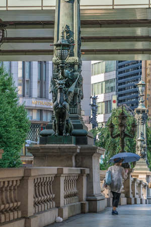 Nihonbashi, Tokyo -  August 26, 2018 : Old lady with umbrella and (Kirin) dragon shaped sculpture at Nihonbashi bridge. Starting point of japan's five major highwaysのeditorial素材