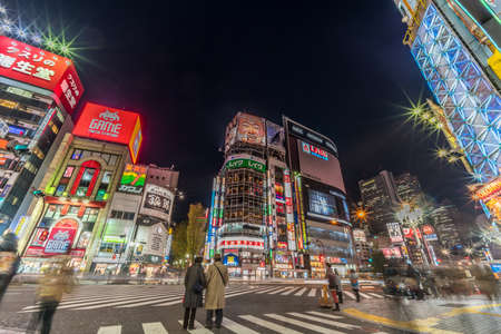 Kabukicho, Shinjuku, Tokyo, Japan - November 20, 2017 : Colorful busy Street and Billboards. Motion blurred People passing along Shops around Yakusuni Dori junction at night.のeditorial素材