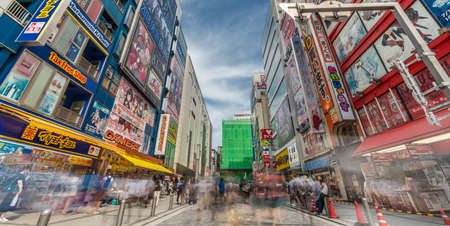 Tokyo, Taito Ward, Akihabara - August 19, 2018 : Panoramic view of Motion blurred people walking along shops and Colorful Billboard Advertisements at famous Akihabara Electric Townのeditorial素材