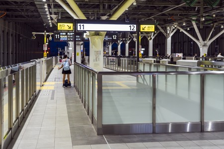 TOKYO, JAPAN - OCTOBER 5, 2018. School Girl Is Waiting For A Shinkansen At Train Station In Japan.