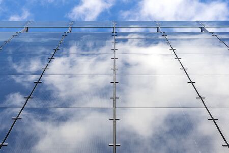Glass And Aluminum And Blue Sky And Modern Architecture. Clouds Are Reflecting In The Glazing Facade And Aluminium Panels.の写真素材
