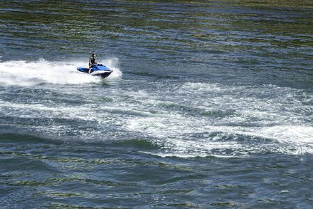 Man is Riding The Ski Jet. Water Splashes from Fast Speed Boat.の写真素材
