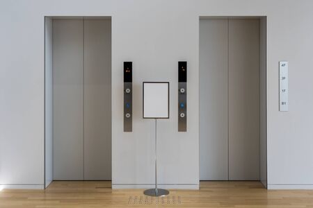 Grey Lobby and Two Lifts. Couple Elevations and a Sign.の写真素材