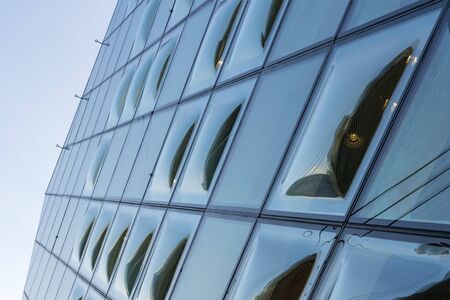 Close-Up View of Double Curve Convex Glass Windows. Reflected Clear Glazing Facade System. The...