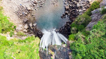 Looking Down Aerial View of The High Waterfall Jeongbang and Lagoon on Jeju Island, South Korea.の写真素材