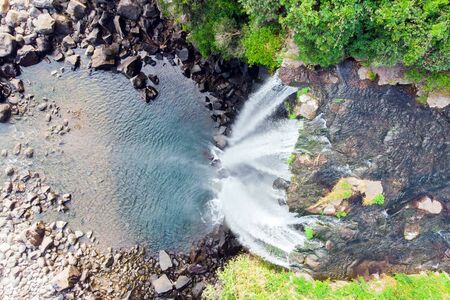 Looking Down Aerial View of The High Waterfall Jeongbang and Lagoon on Jeju Island, South Korea.