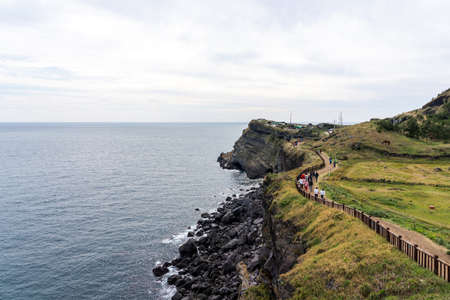 JEJU ISLAND, SOUTH KOREA - NOVEMBER 3, 2018. People Walking along the High Cliff Coast. No 10 Course in Songaksan On Jeju island, Korea.のeditorial素材