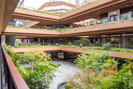 SHANGHAI, CHINA - NOVEMBER 10, 2018. Ruihong Tiandi Shopping Mall. External Courtyard of a Retail Complex with Lush Greenery. Garden with Footbridge and Terraces. Green Sustainable Architecture.のeditorial素材