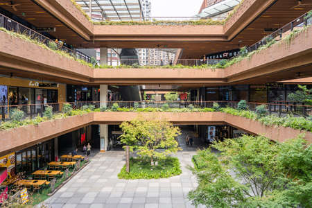 SHANGHAI, CHINA - NOVEMBER 10, 2018. Ruihong Tiandi Shopping Mall. External Courtyard of a Retail Complex with Lush Greenery. Garden with Footbridge and Terraces. Green Sustainable Architecture.のeditorial素材
