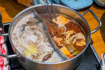 Customized combo pot with boiling hot soups, one spicy flavor and one mushroom flavor.の写真素材