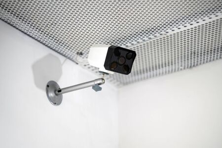 CCTV camera are installed on the wall. Security cam is in white interior background.