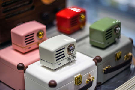 SHANGHAI, CHINA - NOVEMBER 28, 2018. Retro film photo with blurred background. Vintage style small radio are in a gift shop. Modern speakers stylized to old and colorful design devices.のeditorial素材