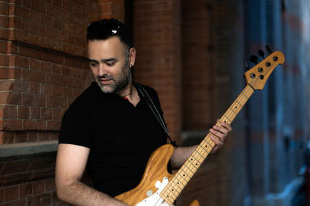 Handsome Male Person is Playing on Bass Guitar on Street. Caucasian Young Person Performing at...