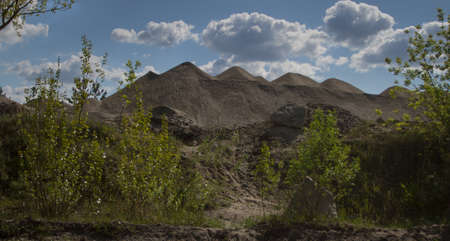 Huge mountains towering heaps of waste to tens of meters above the roadの写真素材
