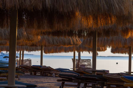 Umbrellas, beach chairs, tents on the beach in the sun when the dawn.の写真素材