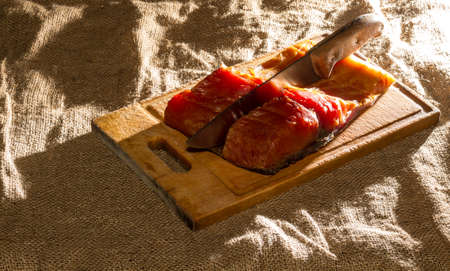 Smoked fish,wooden board, knife, burlap.の写真素材