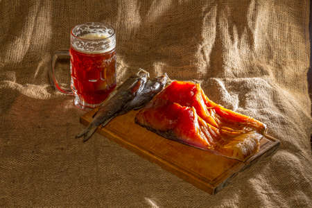 Smoked fish, dried fish, wooden board, beer, burlap.の写真素材