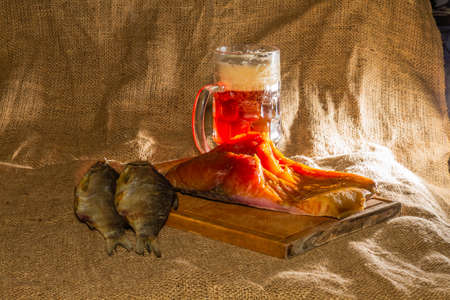 Smoked fish, dried fish, wooden board, beer, burlap.の写真素材