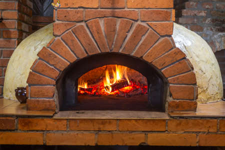 Fire and burn coals in stone ovens. Oven made of brick and clay on the wood. Oven for pizza. Brick oven.の写真素材
