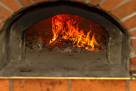 Fire and burn coals in stone ovens. Oven made of brick and clay on the wood. Oven for pizza. Brick oven.の写真素材