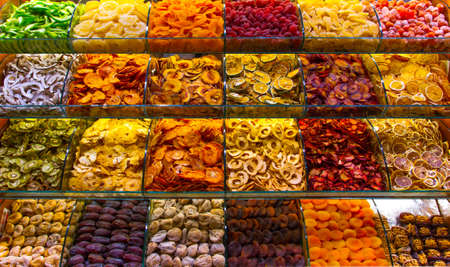 Multicolored oriental spices, teas, dried fruits and nuts on the counter in the eastern marketの写真素材