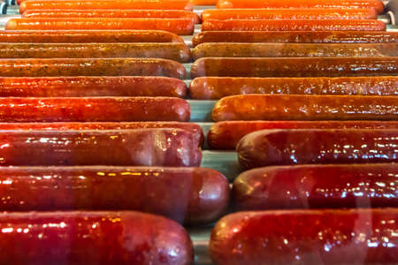 Appetizing snag, 
sausage, banger, frankfurter, weenie, snag, red-hot of different types are fried on an electric grill. Soon they will make hotdogs.の写真素材