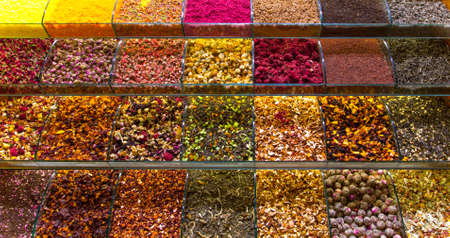 Multicolored oriental spices, teas, dried fruits and nuts on the counter in the eastern marketの写真素材