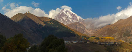 The Trinity Church in Gergeti is located at an altitude of 2,170 m at the foot of Kazbek along the Georgian Military Road in the Georgian village of Gergeti on the right bank of the river Cheheri, directly above the village of Stepantsminda.の写真素材