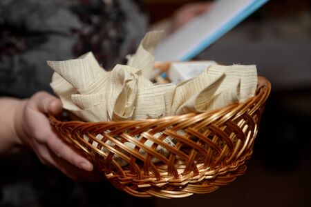 Woman holding a wicker basket with a cloth packets.の写真素材
