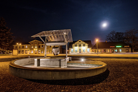 DOBELE, LATVIA - NOVEMBER 4, 2014: The city market square with wells at evening lights.のeditorial素材