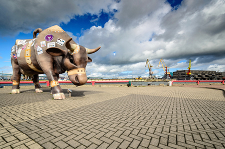 VENTSPILS, LATVIA, JULY 9, 2012:  Cow - travel suitcase sculpture at harbor promenade.のeditorial素材