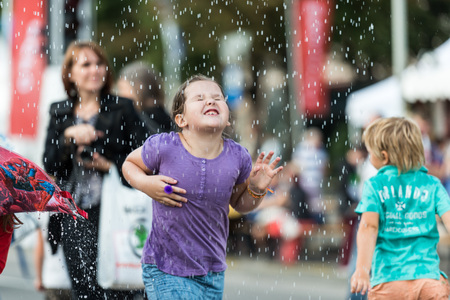 RIGA, LATVIA - AUGUST 17, 2014: People on the streets of Riga City Festival. Children are happy with water attractions.のeditorial素材