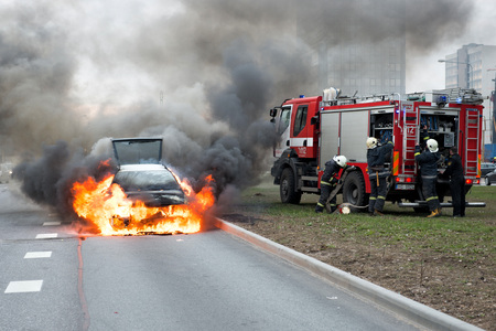 RIGA, LATVIA - APRIL 11, 2014: A few minutes in the street burnt car. Traffic is stopped. Firefighters eliminate fire.のeditorial素材