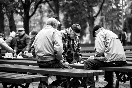RIGA, LATVIA - OCTOBER 11, 2013: Men in the park on a bench playing chess.のeditorial素材