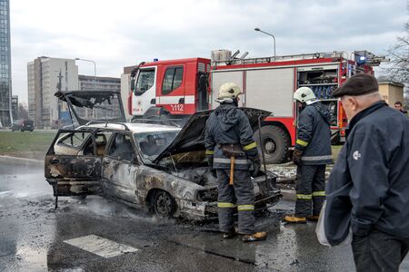 RIGA, LATVIA - APRIL 11, 2014: A few minutes in the street burnt car. Traffic is stopped....