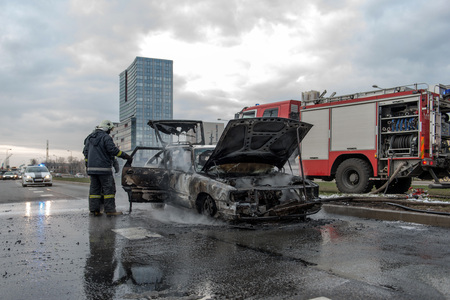 RIGA, LATVIA - APRIL 11, 2014: A few minutes in the street burnt car. Traffic is stopped....