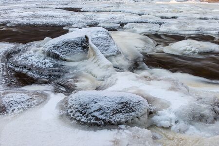 Winter landscape. Frozen rocky river. Ice and snow.の写真素材