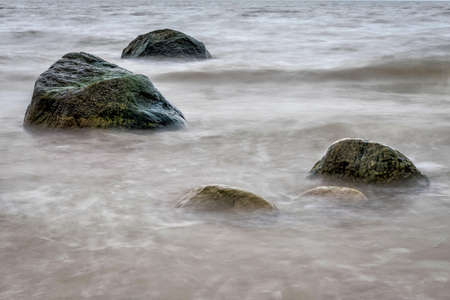 Marine waters surrounded by lone large stones.の写真素材
