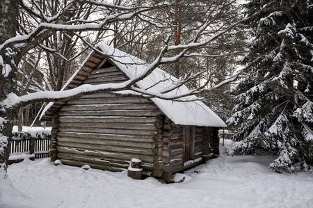 Winter landscape. White snow-covered log house.の写真素材