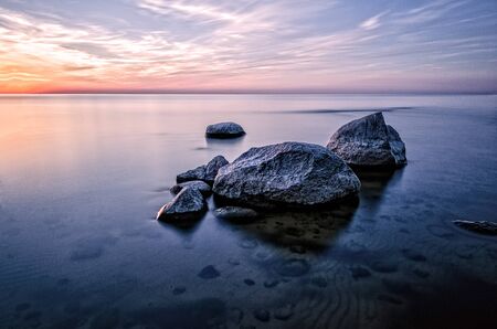 The stones in the sea at sunset.の写真素材