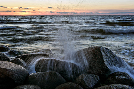 The ninth wave. Baltic Sea rocky beach at sunset.の写真素材
