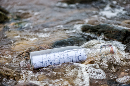 Flushed from the sea old bottle with a message.の写真素材