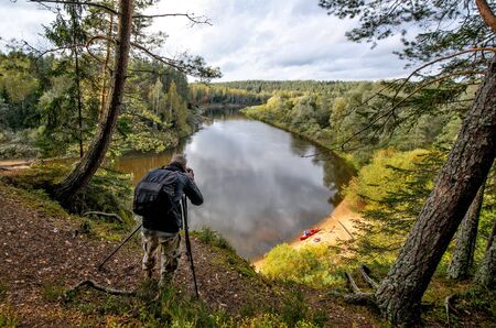 Photographer on the cliff take landscape picture.の写真素材