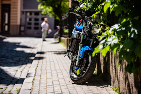 Side of the street at the door of a parked bike. A sunny day in the streets.の写真素材